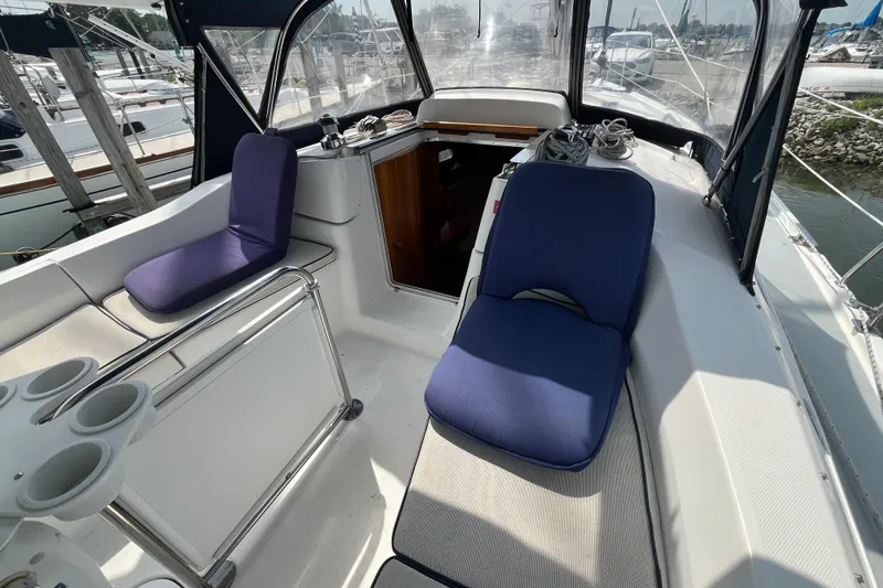 Slide: The Image of 2006 Hunter 36-2 sailboat cockpit with blue cushioned seating and cup holders. - 13