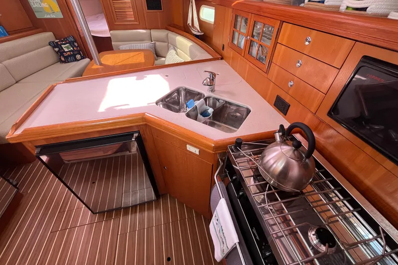 Slide: The Image of Cozy 2006 Hunter 36-2 yacht interior with kitchenette, sink, and seating area. - 18