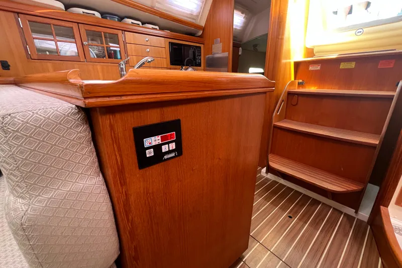 Slide: The Image of Interior of a 2006 Hunter 36-2 sailboat with wooden cabinetry and stairs. - 27