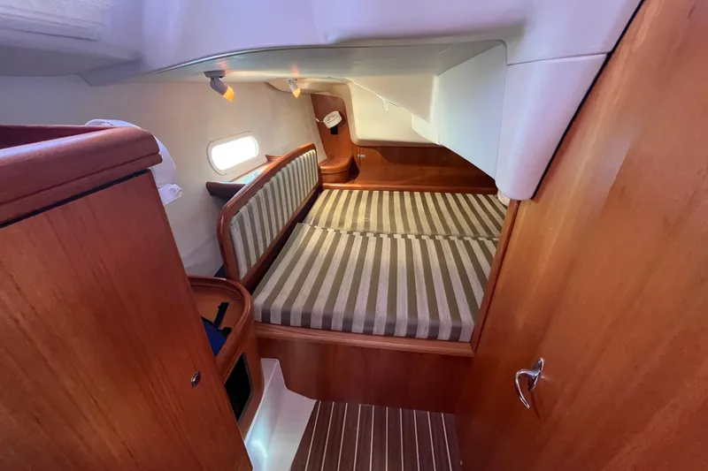 Slide: The Image of Cozy cabin interior of 2006 Hunter 36-2 sailboat with striped bedding and wooden finishes. - 28