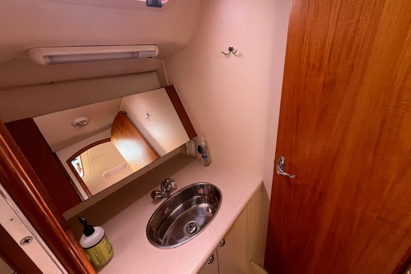 Slide: The Image of Compact bathroom in 2006 Hunter 36-2 yacht with sink, mirror, and wooden door. - 31