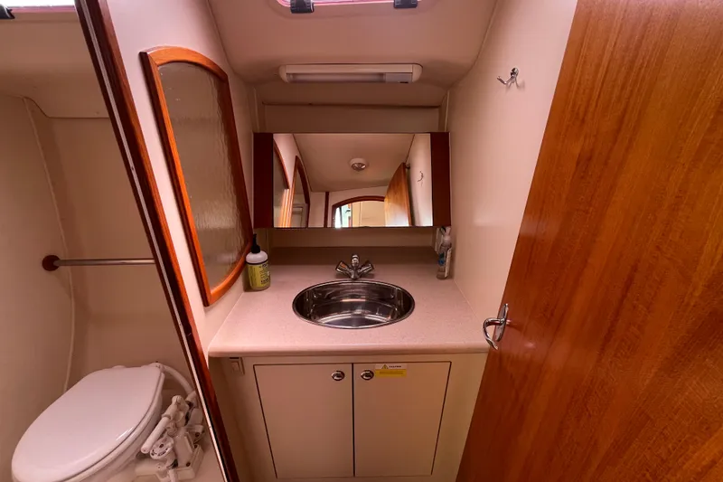 Slide: The Image of Compact bathroom in a 2006 Hunter 36-2 sailboat with sink, mirror, and toilet. - 32
