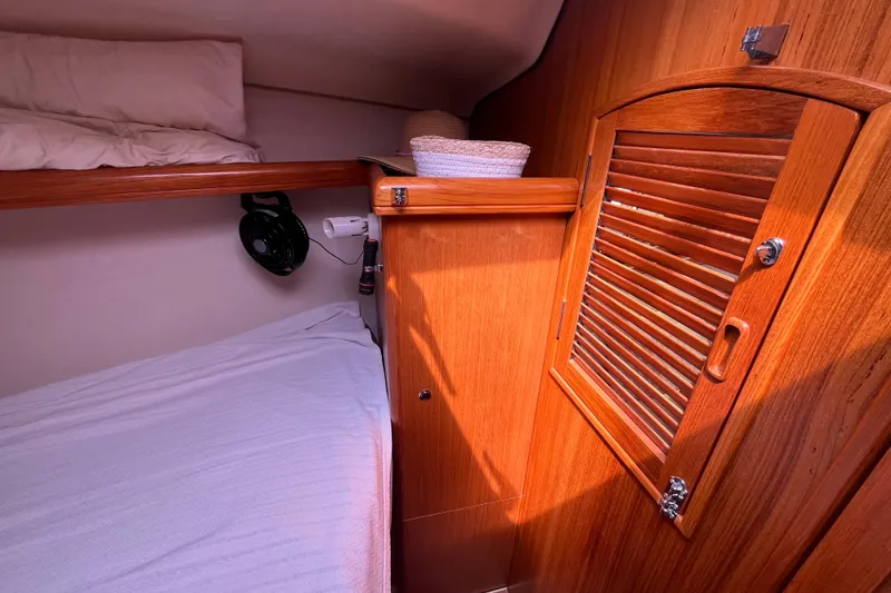 Slide: The Image of Cozy cabin interior of 2006 Hunter 36-2 sailboat with wooden finishes and bedding. - 35