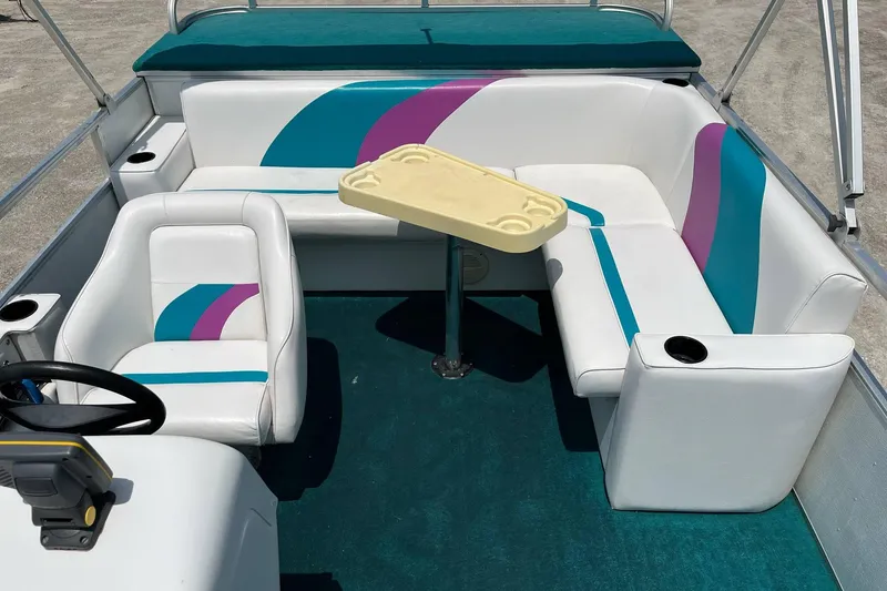 Slide: The Image of 1998 Sundancer Pontoons 240 interior with colorful seating and table. - 10