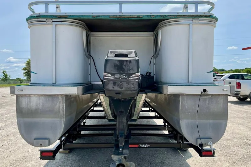 Slide: The Image of 1998 Sundancer Pontoons 240 on trailer, featuring dual pontoons and an outboard motor. - 14
