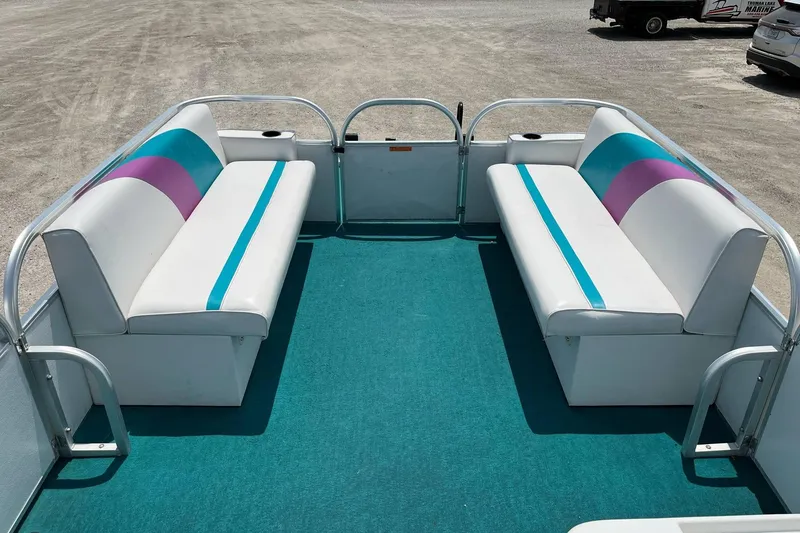 Slide: The Image of 1998 Sundancer Pontoons 240 interior with teal and purple seating on a blue carpet. - 2