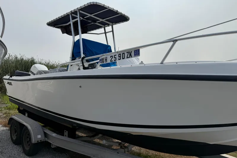 Slide: The Image of 2001 Mako 221 Center Console boat on trailer, side view, with canopy and registration visible. - 2