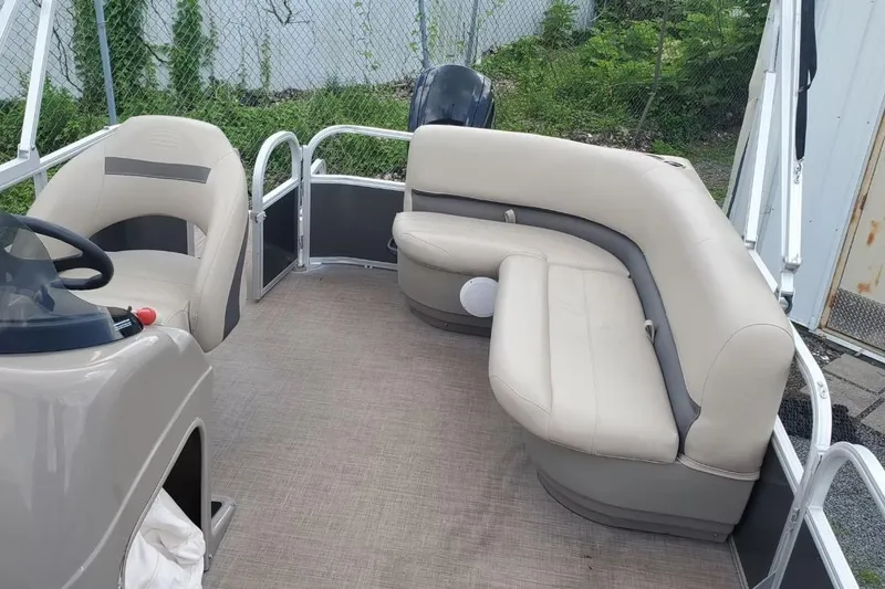Slide: The Image of 2020 Sun Tracker Party Barge 180 DLX interior with beige seating and steering console. - 3