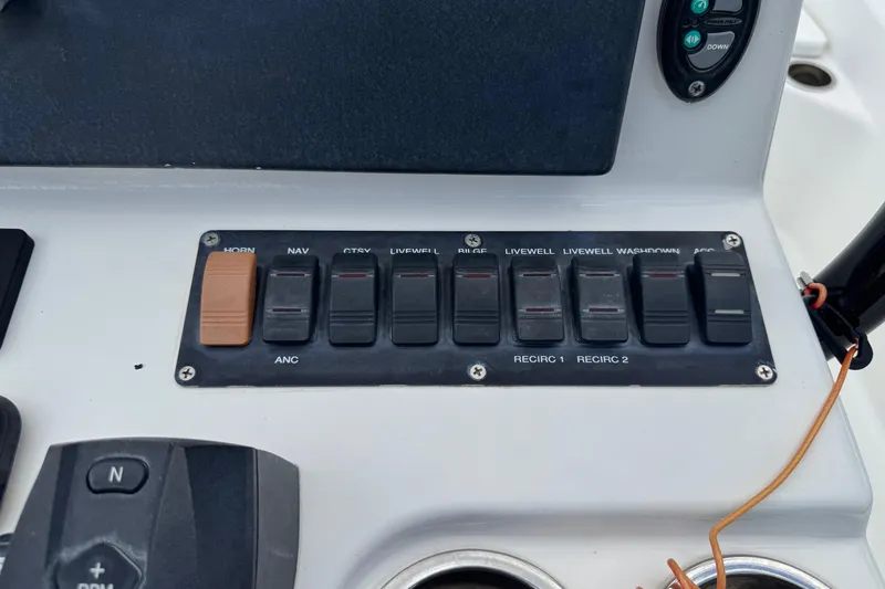 Slide: The Image of Control panel of a 2015 BlackJack 224 Bay boat with labeled switches. - 14
