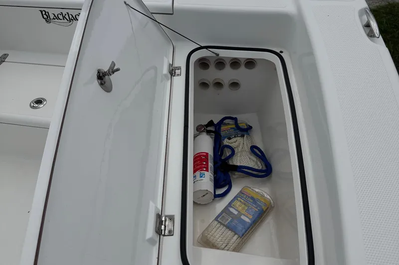 Slide: The Image of Open storage compartment on 2015 BlackJack 224 Bay boat with ropes and fire extinguisher. - 21