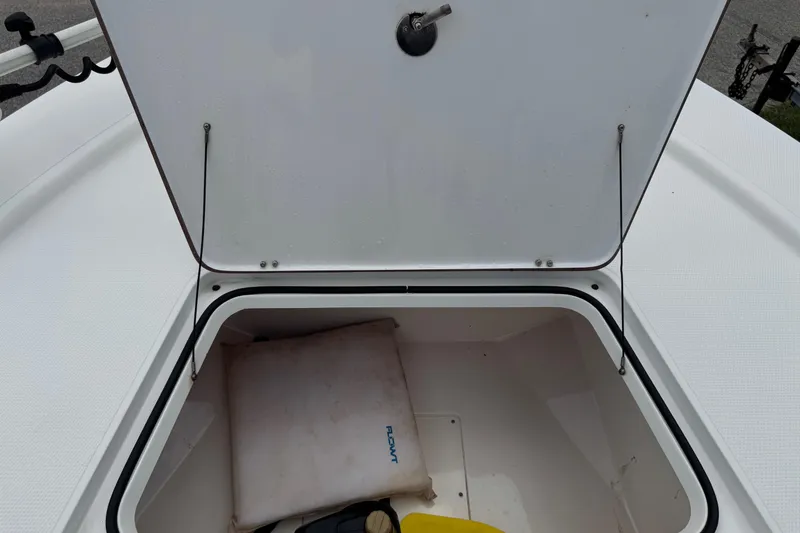 Slide: The Image of Open storage compartment on a 2015 BlackJack 224 Bay boat, showing interior contents. - 24