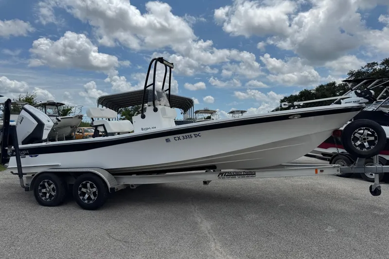 Slide: The Image of 2015 BlackJack 224 Bay boat on trailer under cloudy sky. - 28