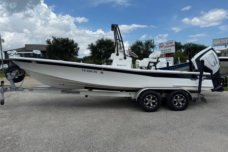 Slide: The Image of 2015 BlackJack 224 Bay boat on trailer, parked outdoors under cloudy sky. - 30