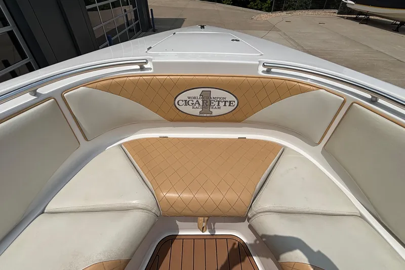 Slide: The Image of 2014 Cigarette 39 GTS boat interior with tan and white seating, featuring logo. - 34