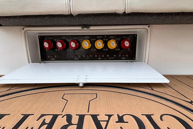 Slide: The Image of Control panel of a 2014 Cigarette 39 GTS boat with labeled switches and wooden flooring. - 50