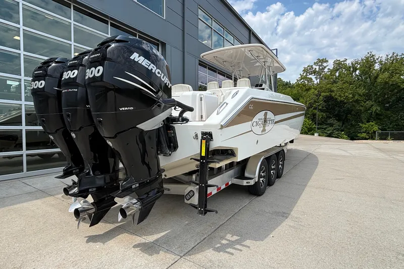 Slide: The Image of 2014 Cigarette 39 GTS boat with triple Mercury 300 engines, parked outdoors. - 6