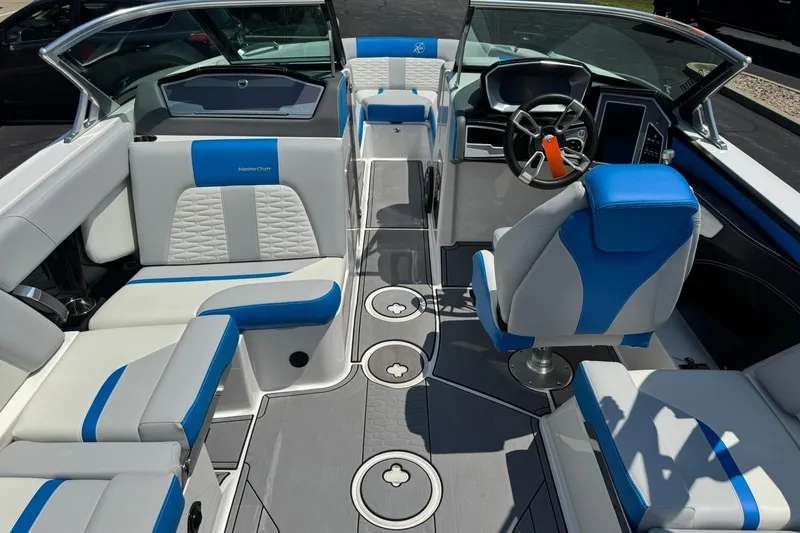 Slide: The Image of 2020 MasterCraft X24 boat interior with blue and white seating and modern dashboard. - 11