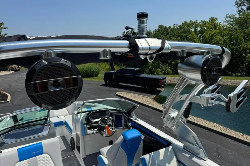 Slide: The Image of 2020 MasterCraft X24 boat interior with speakers and sleek design near a pond. - 14