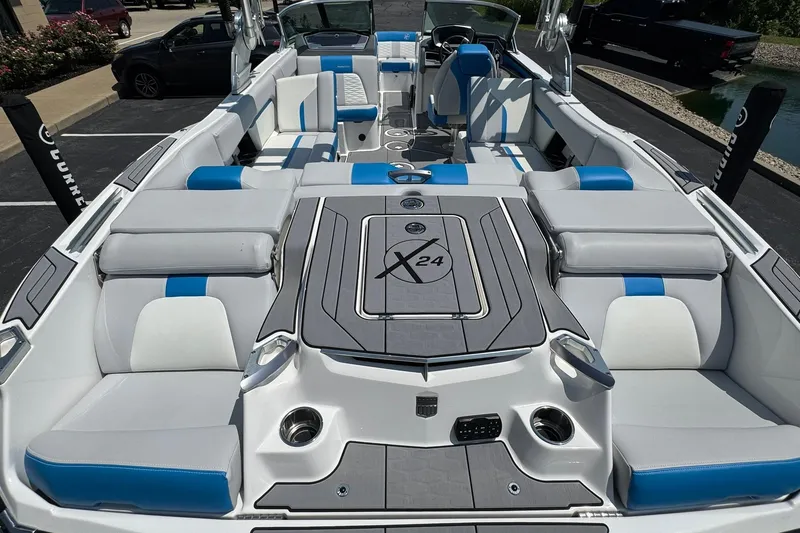Slide: The Image of 2020 MasterCraft X24 boat interior with gray and blue seating, spacious layout. - 16