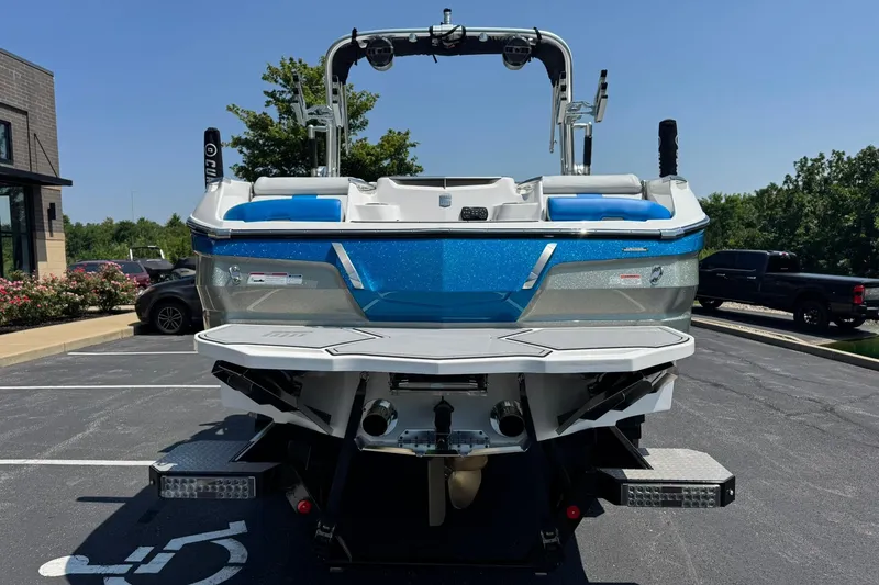 Slide: The Image of 2020 MasterCraft X24 boat in parking lot, rear view, blue and white design. - 4