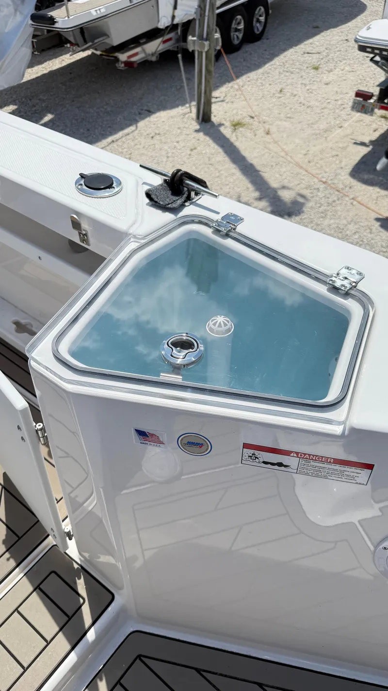 Slide: The Image of 2026 Cutwater C-288 Coupe boat deck with storage compartment and safety labels. - 13