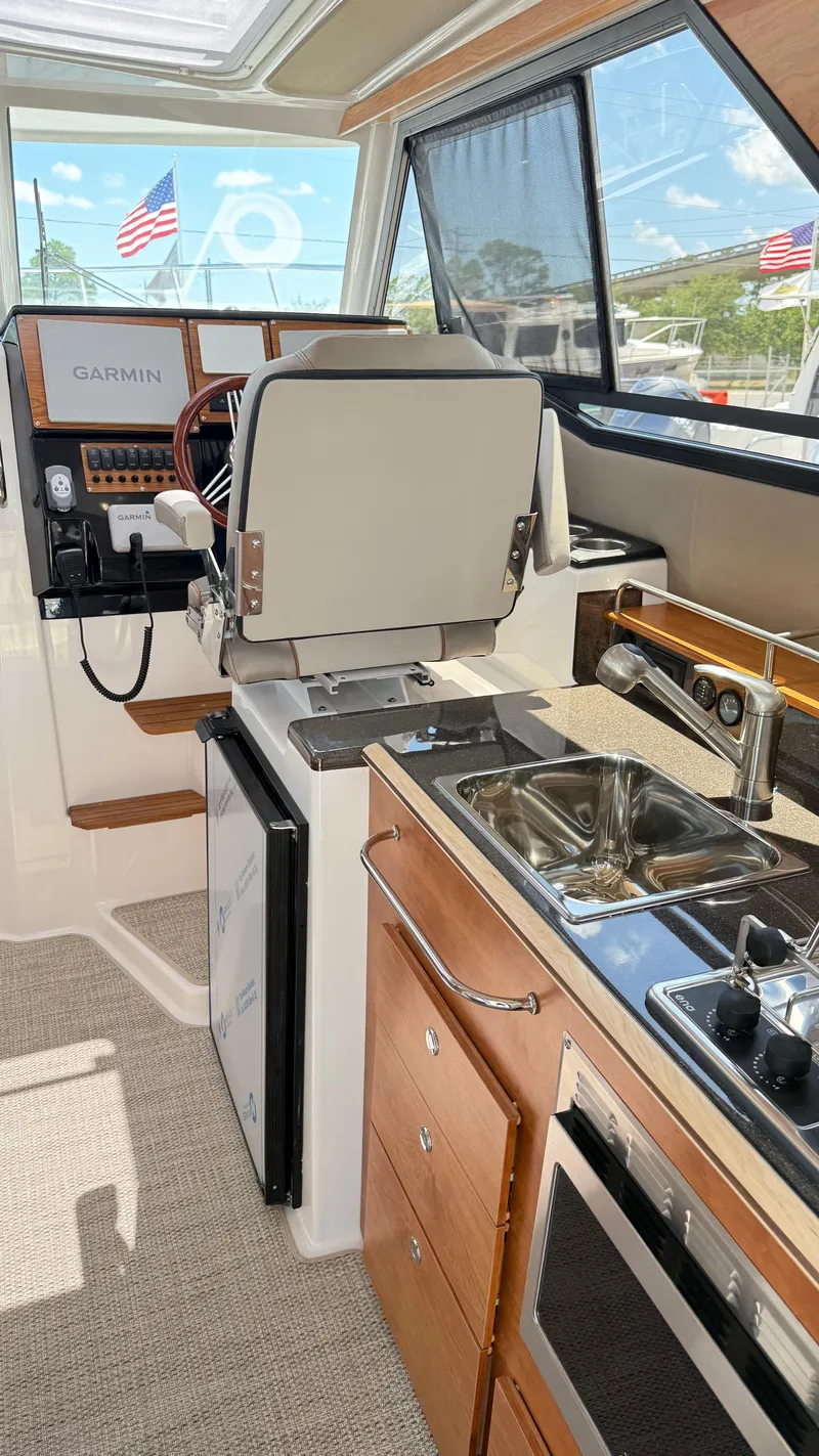 Slide: The Image of Interior of 2026 Cutwater C-288 Coupe featuring helm, kitchen sink, and appliances. - 30
