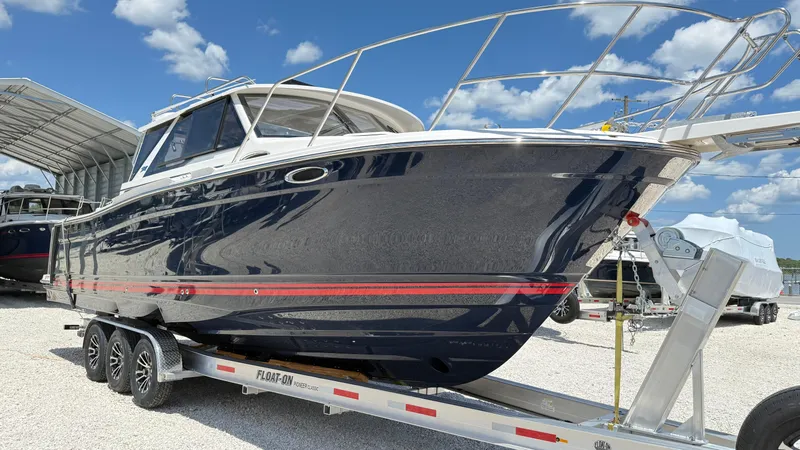 Slide: The Image of 2026 Cutwater C-288 Coupe boat on trailer under blue sky. - 4