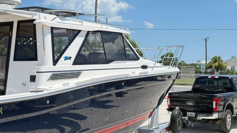 Slide: The Image of 2026 Cutwater C-288 Coupe boat on trailer, parked beside a black Ford truck. - 5