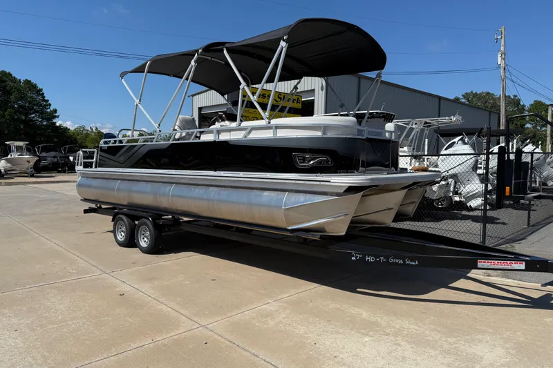 The Image of 2026 Avalon Venture 85 Versatile rear Bench pontoon boat on trailer, outdoor dealership display. - 0