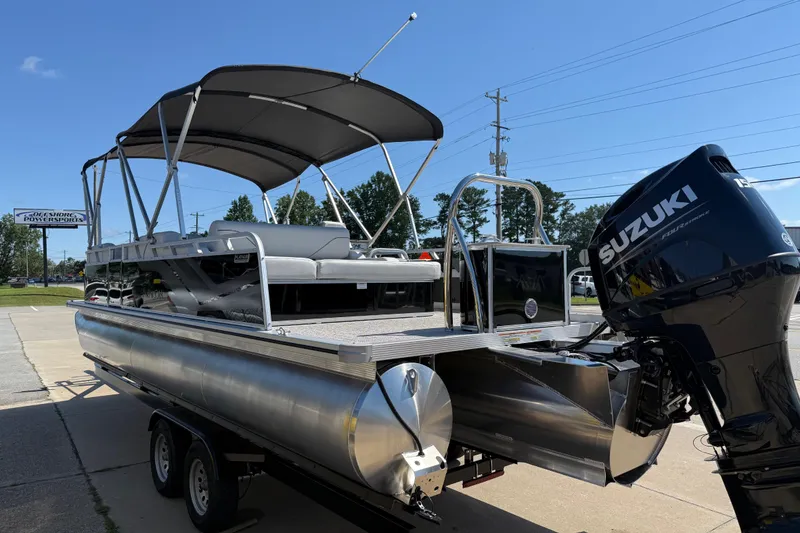 Slide: The Image of 2026 Avalon Venture 85 Versatile rear Bench pontoon boat with Suzuki engine, parked outdoors. - 6