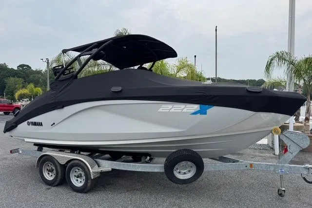 Slide: The Image of 2023 Yamaha Boats 222XD on trailer, covered, parked outdoors. - 2