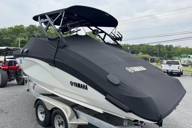 Slide: The Image of 2023 Yamaha Boats 222XD covered on trailer, black cover, outdoor setting. - 3