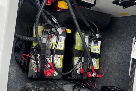 Slide: The Image of 2023 Yamaha Boats 222XD battery compartment with wiring and connections. - 8