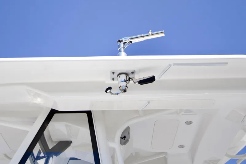 Slide: The Image of 2026 Regulator 28 boat with mounted fishing rod holder against clear blue sky. - 11
