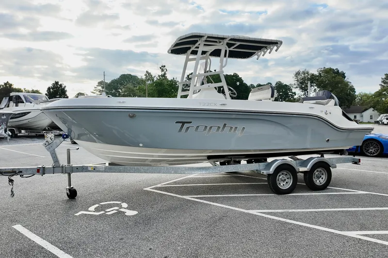 Slide: The Image of 2024 Bayliner TROPHY 22 CX boat on trailer in parking lot, cloudy sky background. - 4
