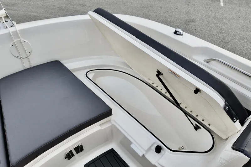 Slide: The Image of 2024 Bayliner TROPHY 22 CX boat with open storage compartment and cushioned seating. - 7