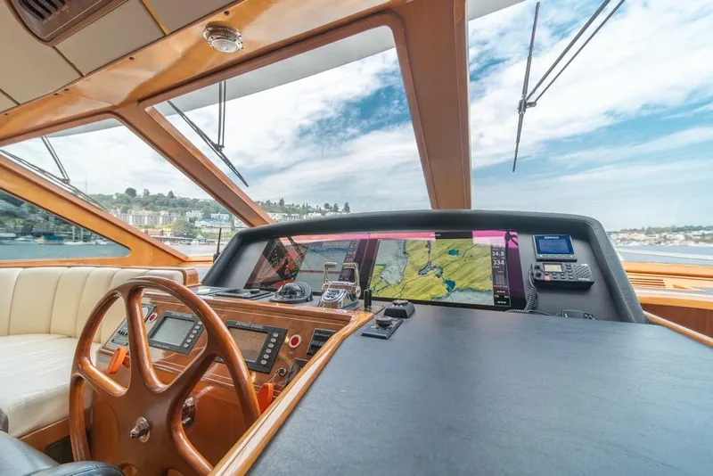 Slide: The Image of 2005 Ocean Alexander 64 Motoryacht helm with navigation screens and wooden steering wheel. - 23