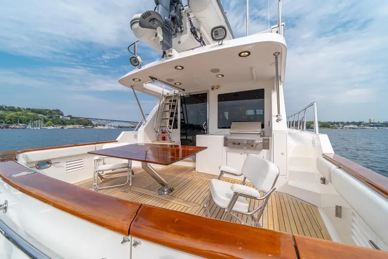 Slide: The Image of 2005 Ocean Alexander 64 Motoryacht deck with seating, table, and grill, overlooking water. - 48