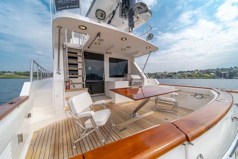 Slide: The Image of 2005 Ocean Alexander 64 Motoryacht deck with seating and table, overlooking water. - 49