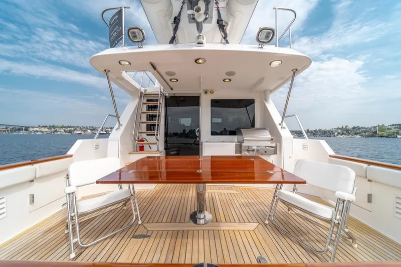 Slide: The Image of 2005 Ocean Alexander 64 Motoryacht deck with table, chairs, and scenic water view. - 50