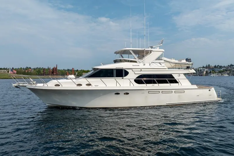 Slide: The Image of 2005 Ocean Alexander 64 Motoryacht cruising on a calm lake under a clear sky. - 6