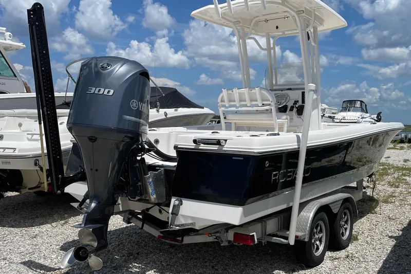 Slide: The Image of 2015 Robalo 246 Cayman boat with Yamaha 300 engine on trailer, under blue sky. - 13