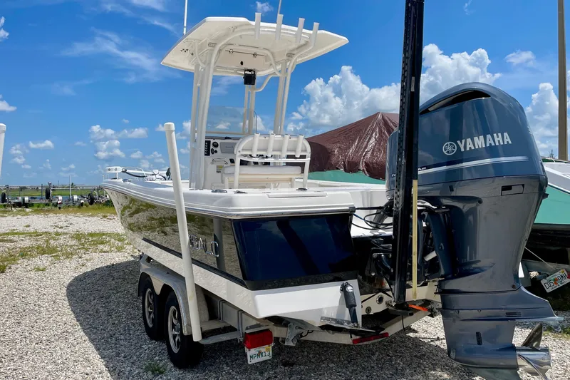 Slide: The Image of 2015 Robalo 246 Cayman boat with Yamaha engine on trailer, under clear blue sky. - 14
