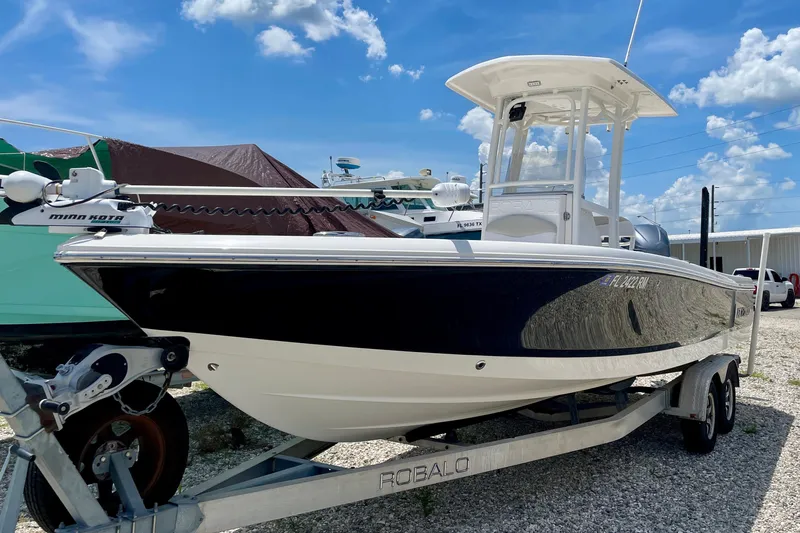 Slide: The Image of 2015 Robalo 246 Cayman boat on trailer under blue sky. - 15