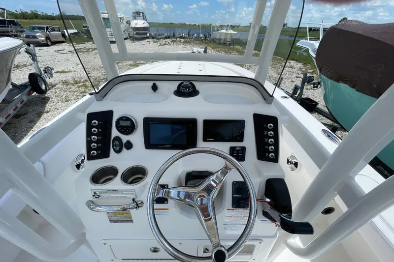Slide: The Image of 2015 Robalo 246 Cayman boat dashboard with steering wheel and navigation controls. - 19