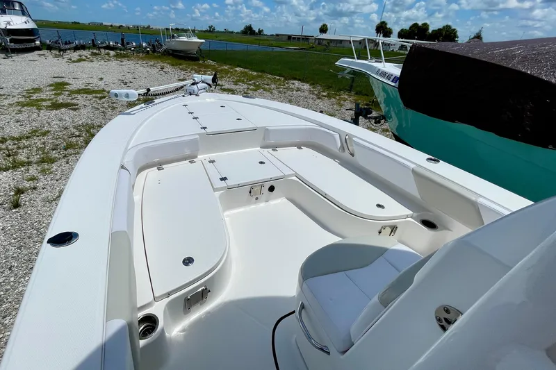 Slide: The Image of 2015 Robalo 246 Cayman boat interior with seating and storage, docked near a lake. - 20