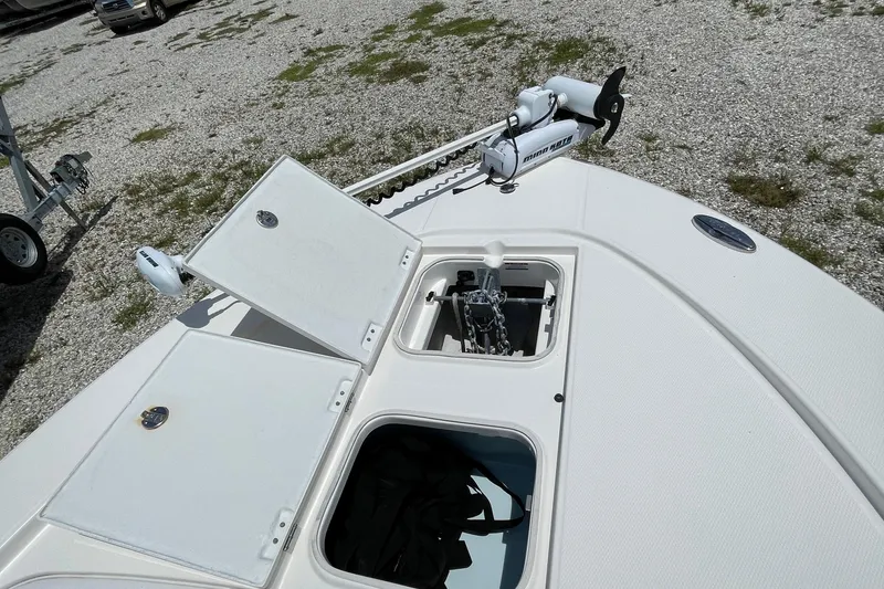 Slide: The Image of 2015 Robalo 246 Cayman boat deck with open storage compartments and trolling motor. - 21