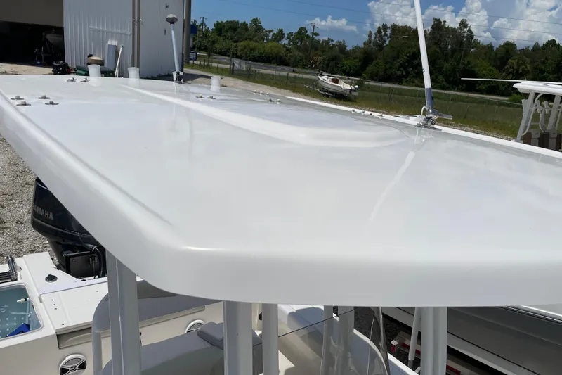 Slide: The Image of 2015 Robalo 246 Cayman boat with T-top, parked outdoors under a clear sky. - 23