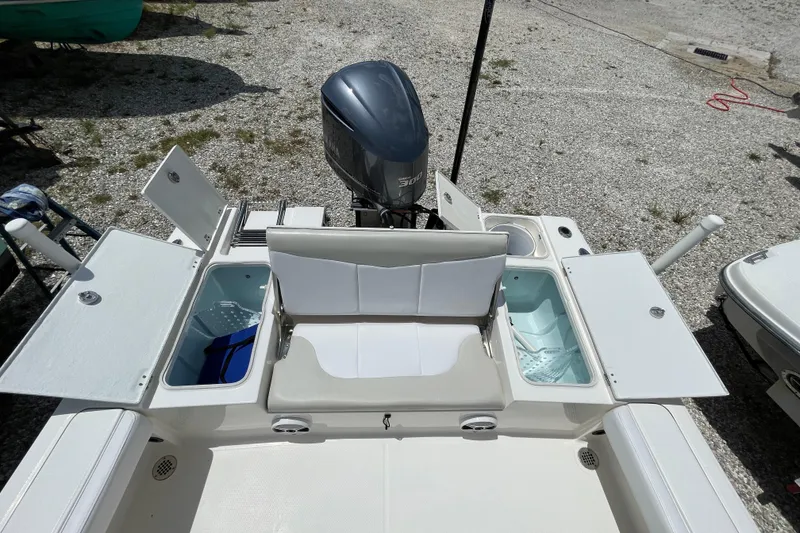 Slide: The Image of 2015 Robalo 246 Cayman boat with open storage compartments and outboard motor. - 5
