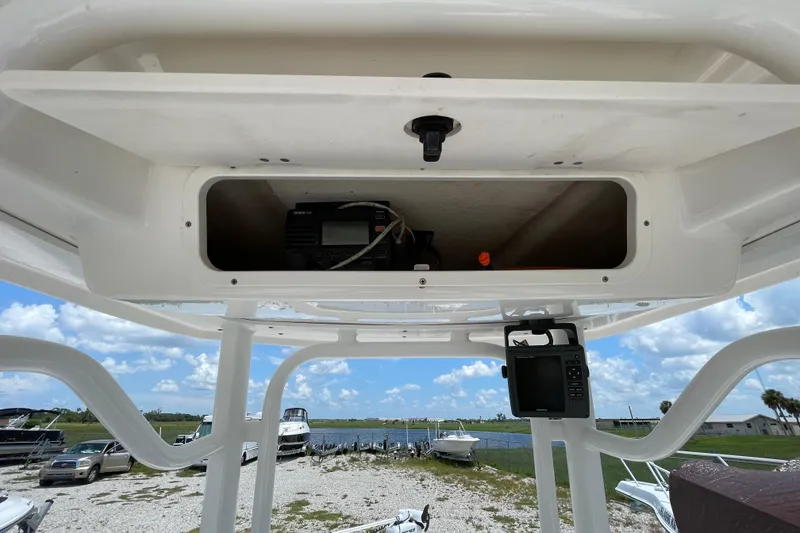 Slide: The Image of 2015 Robalo 246 Cayman boat console with storage and electronic equipment, under a clear blue sky. - 8
